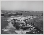 Het huis (vooraan) van Jan Carel van Essen, hoofd Fotografische Dienst van de Curaçaosche Petroleum Industrie Maatschappij, aan de Caracasbaai op Curaçao met op de achtergrond opslagtanks van Shell
