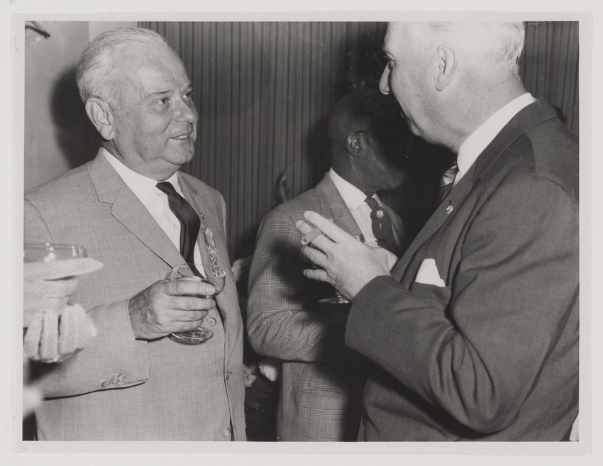 J.C. van Essen (links), hoofd Fotografische Dienst van de N.V. Shell Curaçao, op de receptie ter gelegenheid van zijn benoeming tot Ridder in de Orde van Oranje Nassau in het gouverneurshuis te Willemstad
