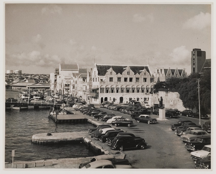Het Gouvernementsplein (vooraan) en de Handelskade in Willemstad met rechts het kantoor van de Koninklijke Nederlandsche Stoomboot Maatschappij