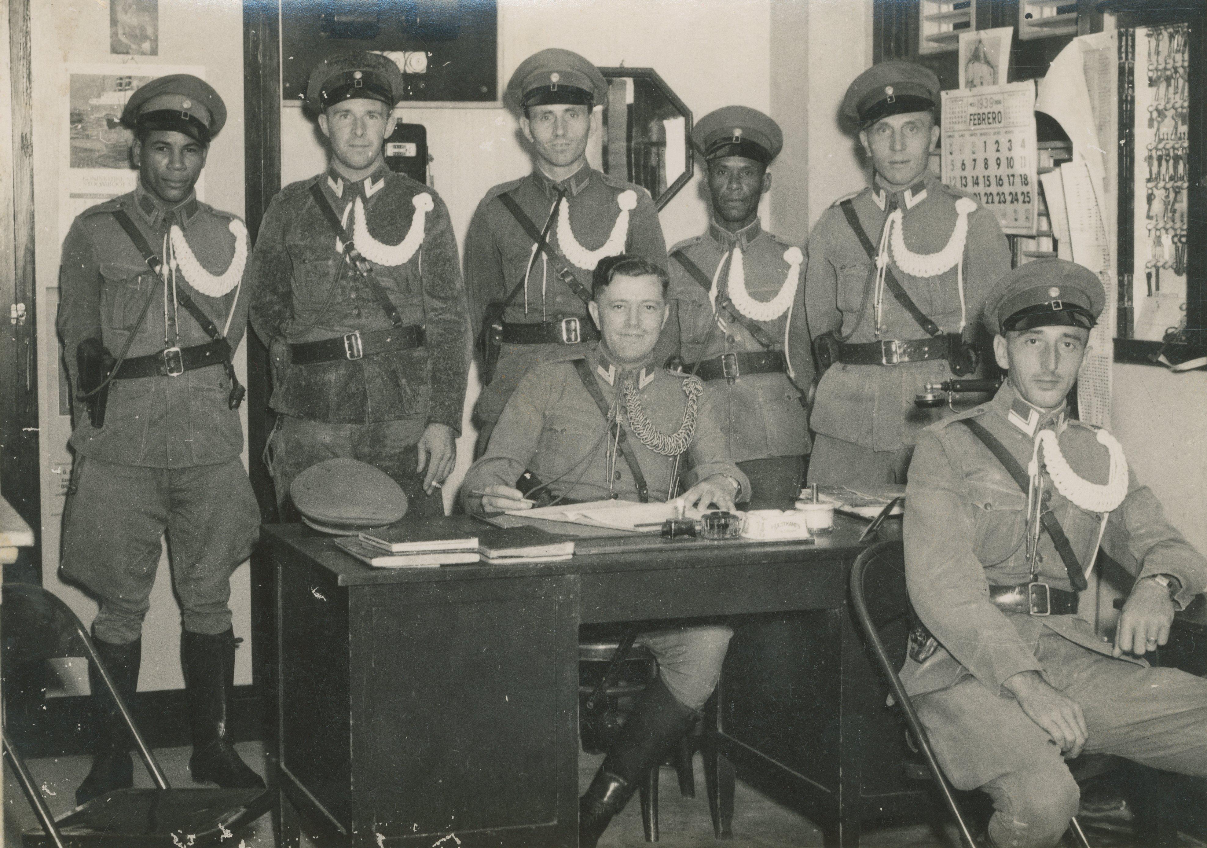 Poserende politiemannen in een politiebureau op Curaçao of Aruba