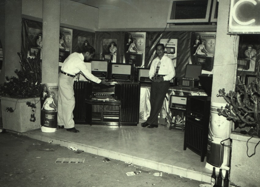 Curaçaosche verkopers in een stand met radios van de Curaçao Trading Company, S.A. (C.T.C.) op een handelsbeurs te Willemstad